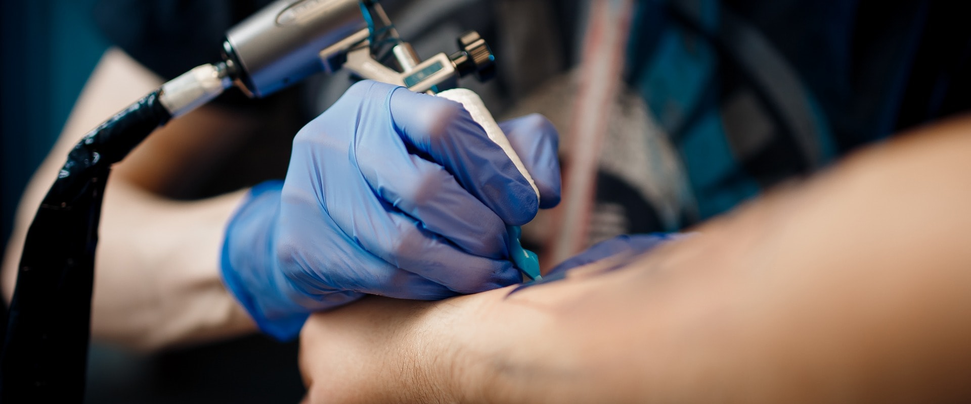 tattoo process machine close-up. master prepares for procedure of drawing